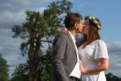 Naturalny portret pary młodej podczas sesji ślubnej, pocałunek na tle dębu